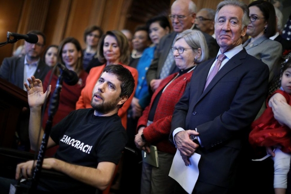 Ady Barkan speaks at a Dec. 19, 2017, press conference against the GOP tax bill organized by congressional Democratic leaders, including House Minority Leader Nancy Pelosi (D-Calif.)
