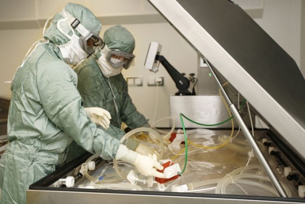 Production operators stand by tubes in a bioreactor as they prepare a cell culture for growing active Ebola vaccine substances in the laboratory of Bavarian Nordic A/S in Kvistgaard, Denmark. At least a half-dozen other drugmakers, including Johnson &amp; Johnson and NewLink Genetics Corp., are developing their own Ebola vaccines