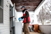 A volunteer goes door to door with bottled water.