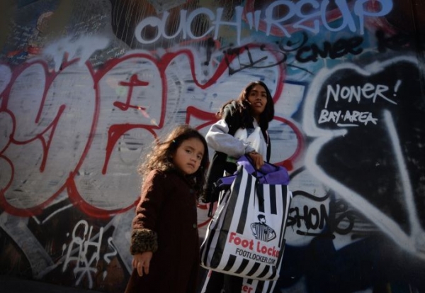 Three-year-old Saria Amaya waits with her mother after receiving shoes and school supplies during a charity event in October to help more than 4,000 underprivileged children at the Fred Jordan Mission in the Skid Row area of Los Angeles. Children from low-income families now make up a majority of public school students in the nation, according to a new report. 