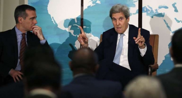 Former Secretary of State John Kerry, next to Los Angeles Mayor Eric Garcetti, speaks during the Boston Climate Summit in Boston on June 7, 2018. 